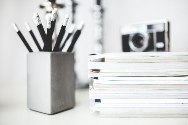 Stack of journals and a pencil on a desk